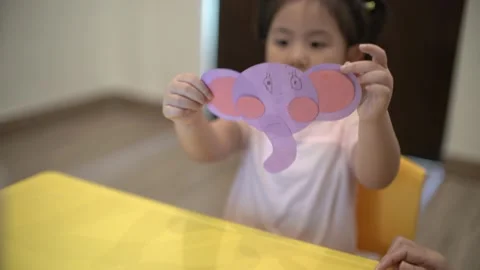 Little child creating elephant shape from colored paper Video stock 159377134