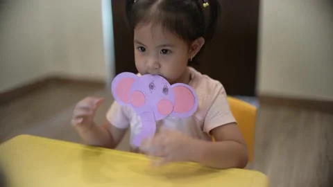 Little child creating elephant shape from colored paper Video stock 159377140