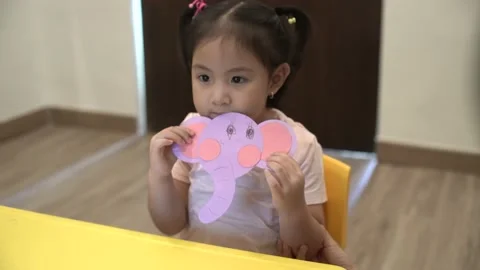 Little child creating elephant shape from colored paper Video stock 159377192