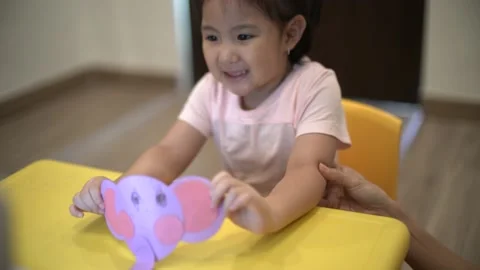 Little child creating elephant shape from colored paper Video stock 159377203