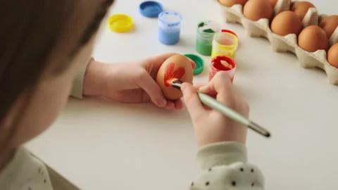 Little child decorates Easter eggs with colored food paint Stock Footage 168713265