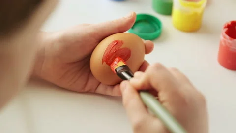 Little child decorates Easter eggs with colored food paint. Stock Footage 168713631
