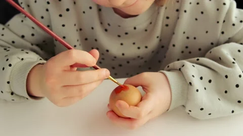 Little child decorates Easter eggs with colored food paint. Stock Footage 170973627