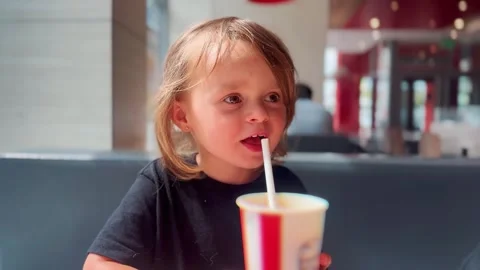 Little Child Drinking Milkshake in Modern Cafe Stock Footage 338321875