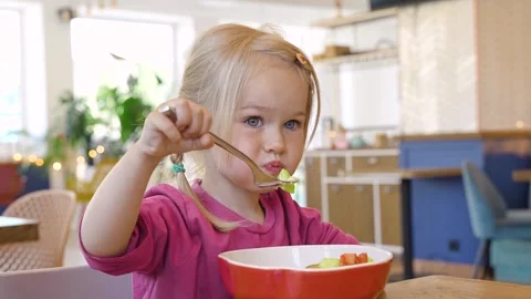 Little child girl eats vegetable salad in restaurant Stock Footage 317170671