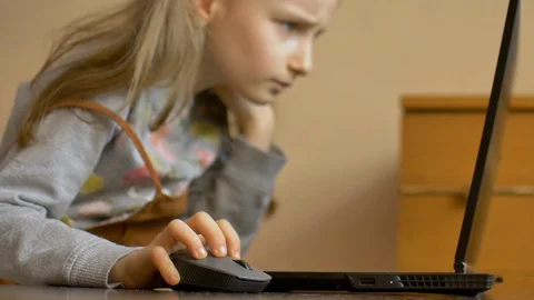 Little child hand is holding a computer mouse on laptop screen background Stock Footage 128836949