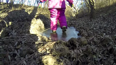Little child learning ice skating on a little lake Stock Footage 53256834