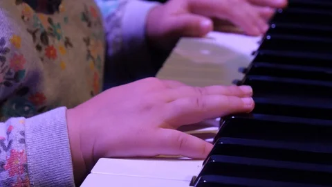 A little child learns to play the piano. Hands of a child on the keys of a piano Stock Footage 127713053