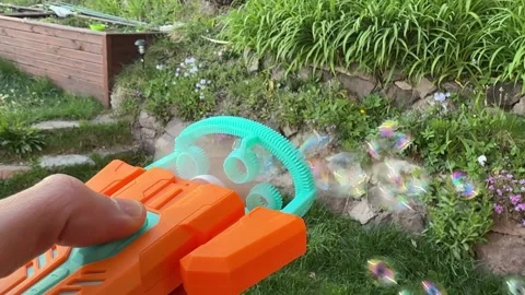 Little Child Making Soap Bubbles with Bubble Toy Outdoors in Garden Stock Footage 334045162