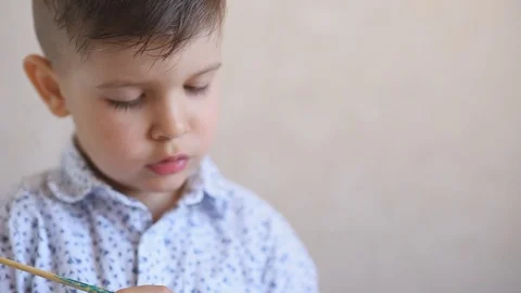 A little child paints an one easter egg at the table on a white background. Stock Footage 121513465