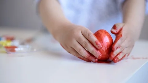 Little child paints an one easter egg at the table on a white background. Stock Footage 121513483