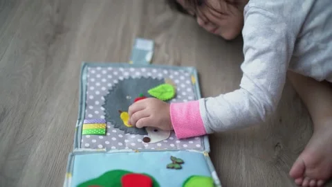 Little child play snapping button on montessori busy book toy Stock Footage 159126090