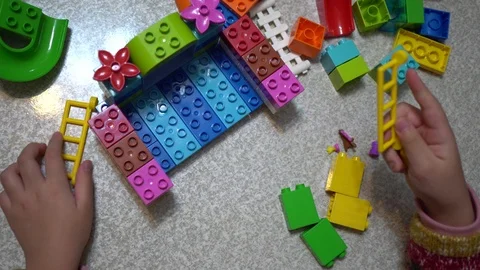 Little child playing with lots of colorful plastic toys indoor. Video stock 100438053