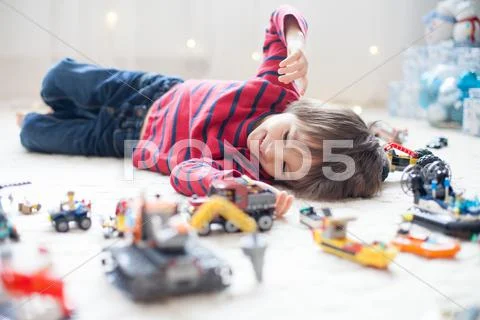 Little child playing with lots of colorful plastic toys indoor Stock Photos