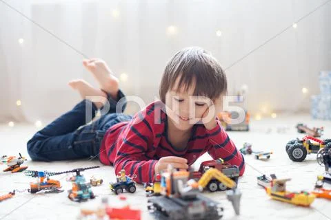 Little child playing with lots of colorful plastic toys indoor Stock Photos