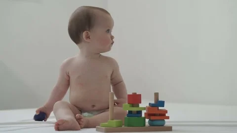 A little child plays with a developing toy Видео 77193211