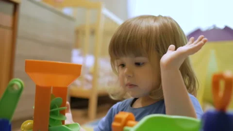 Little Child plays with a multi-colored toy. A preschool boy play in a develo 스톡 동영상 87595991