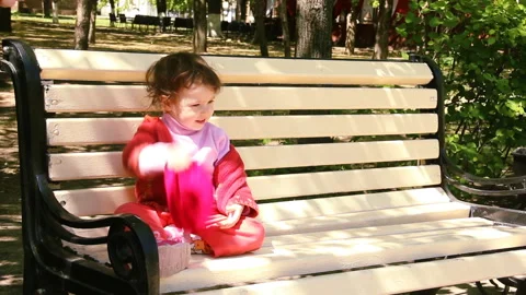 Little child puts on pulls a red hat on his head to the eyebrows. two year old Stock Footage 90265157
