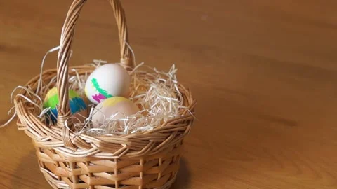 Little Child Putting Painted Easter Egg into Wicker Basket Stock Footage 329248224