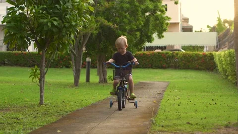 Little child riding a bicycle in park at sunset 4K Stock Footage