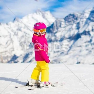 Little child skiing in the mountains Stock Photos