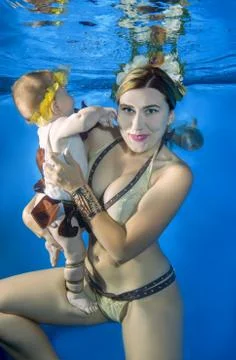 Little child swim underwater in the pool Stock Photos