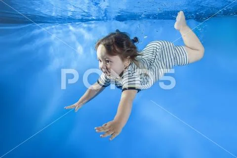 Little child swim underwater in the pool Stock Photos