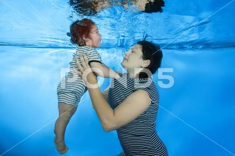 Little child swim underwater in the pool Stock Photos