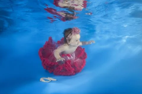 Little child swim underwater in the pool Stock Photos