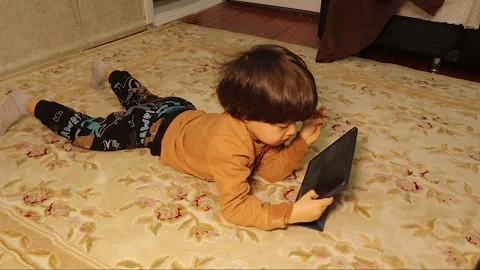 Little child using tablet at home digital learning mobile phone screen time Stockbeeldmateriaal 330549136