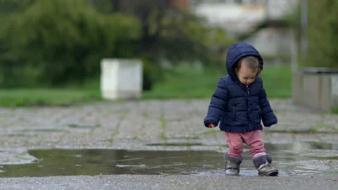 Little child walk through puddle. Stock Footage 237384053