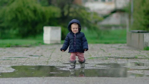 Little child walk through puddle. Stock Footage 237384889