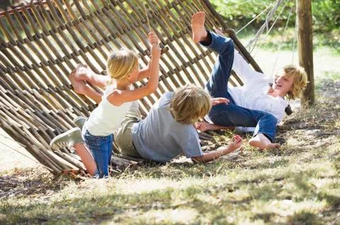 Little children falling down from hammock Stock Photos