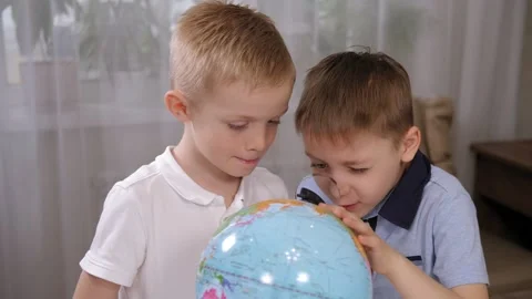 Little children spin the globe and explore continents and countries at home. Stock Footage 329277275