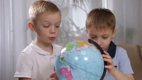 Little children spin the globe and explore continents and countries at home. Stock Footage 329913604