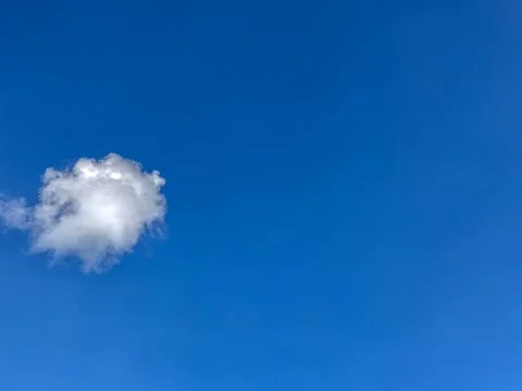 A little cloud in the blue sky. Stock Photos