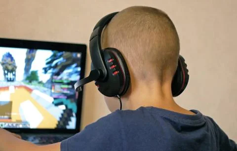 Little computer dependent gamer boy playing on laptop at home Stock Photos