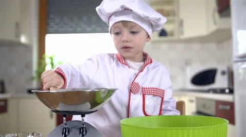 Little cook adding sugar to flour in green bowl Video stock 34430772