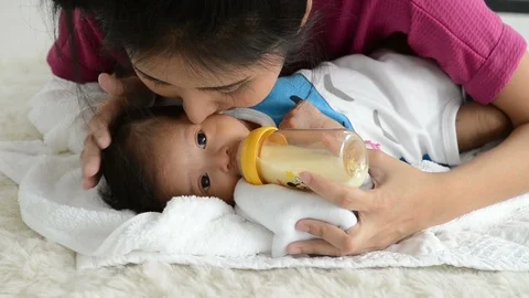 Little cute adorable Asian infant baby drinking Breastfeed through bottle. Stock Footage