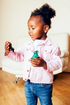 Little cute african american girl playing with animal toys at home, pretty Stock Photos