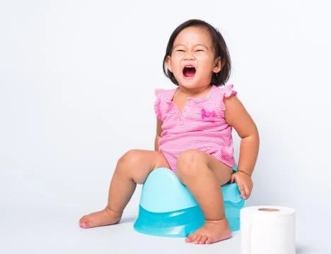 Potty Training. Little cute child girl sitting on a toilet. Stock Photo