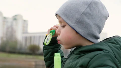 Little cute boy with bubbles by the river, outdoors Vídeos de archivo 106872766