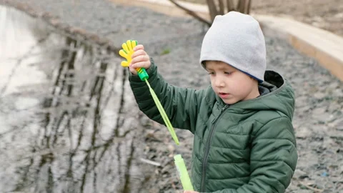 Little cute boy with bubbles by the river, outdoors Stock-Footage 106875916