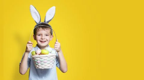 Little cute boy with an Easter basket in his hands and bunny ears on his head Stock Photos