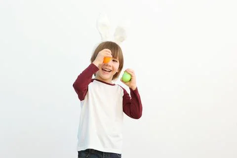 Little cute boy with Easter eggs in his hands and bunny ears on his head Stock Photos