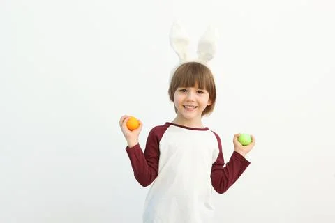 Little cute boy with Easter eggs in his hands and bunny ears on his head Photos