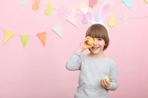 Little cute boy with Easter eggs in his hands and bunny ears on his head Stockfoto's