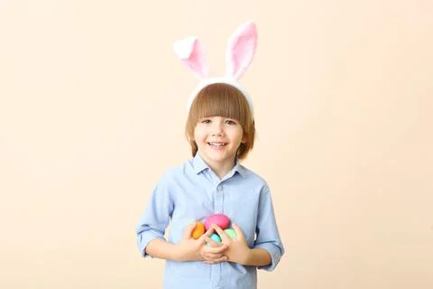 Little cute boy with Easter eggs in his hands and bunny ears on his head Stock Photos