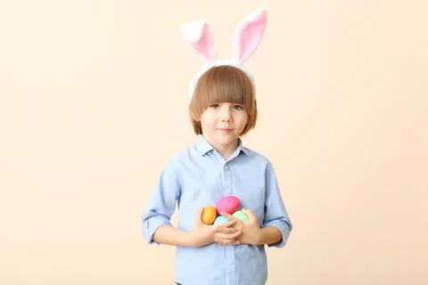 Little cute boy with Easter eggs in his hands and bunny ears on his head Stockfoto's