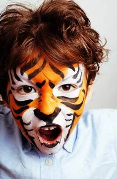 Little cute boy with faceart on birthday party close up, little cute tiger Stock Photos